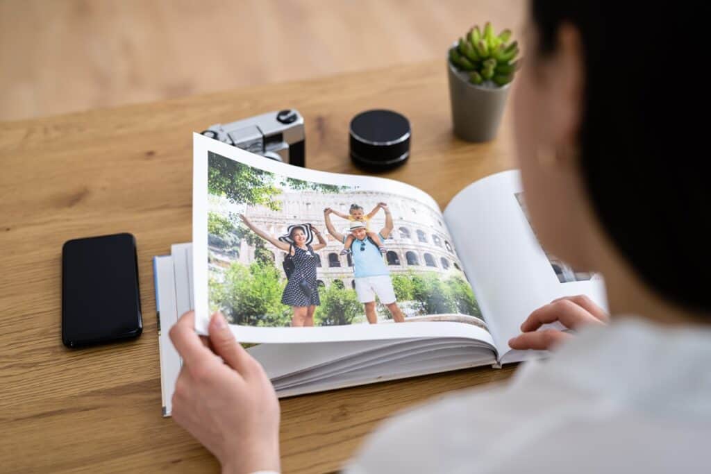 femme regarde un album photo de voyage