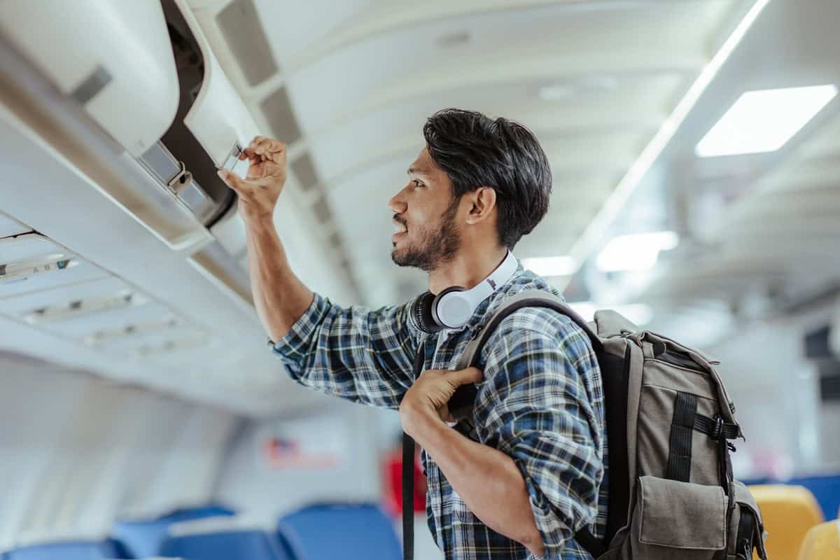 homme avec un sac à dos dans un avion