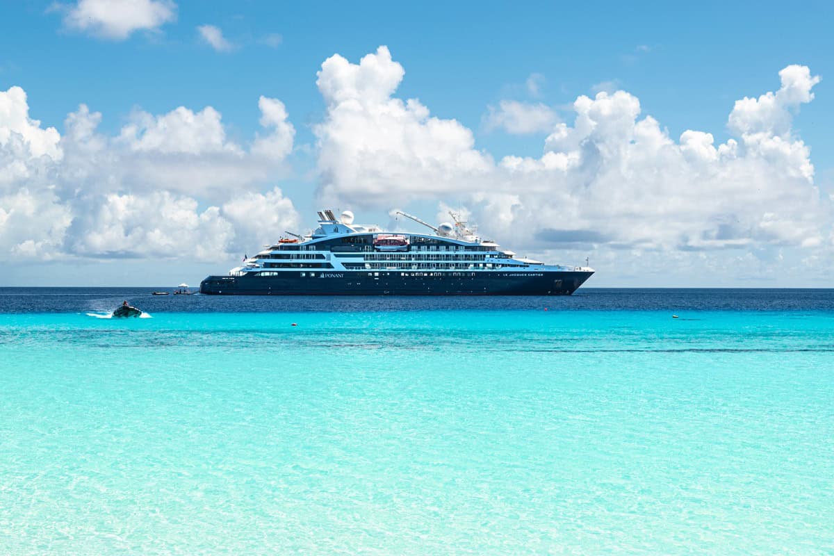 navire de croisière Ponant naviguant dans des eaux turquoises