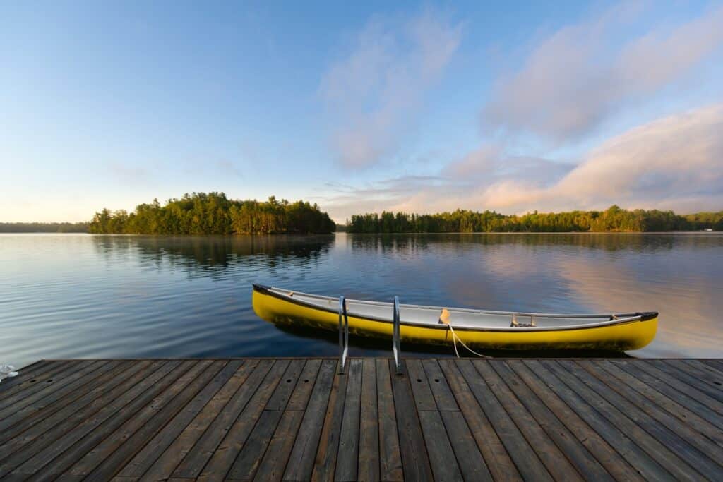 canoe jaune accroché à un ponton en bois