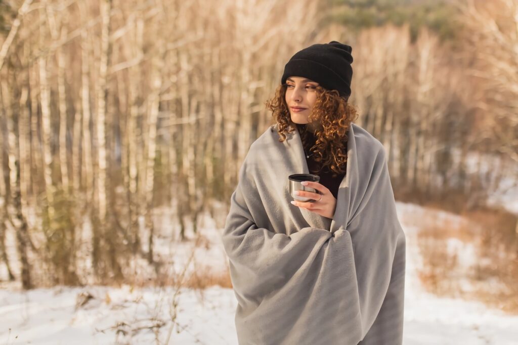 femme sous un plaid dans la neige